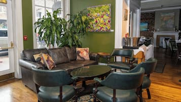 A cozy seating area with leather furniture, a coffee table, and a large plant.