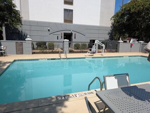Relax by the pool surrounded by lounge chairs and a table.