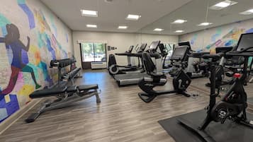 A gym with treadmills, elliptical machines, and free weights.