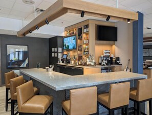 Enjoy a drink at the bar, surrounded by comfortable seating and a flat-screen TV.
