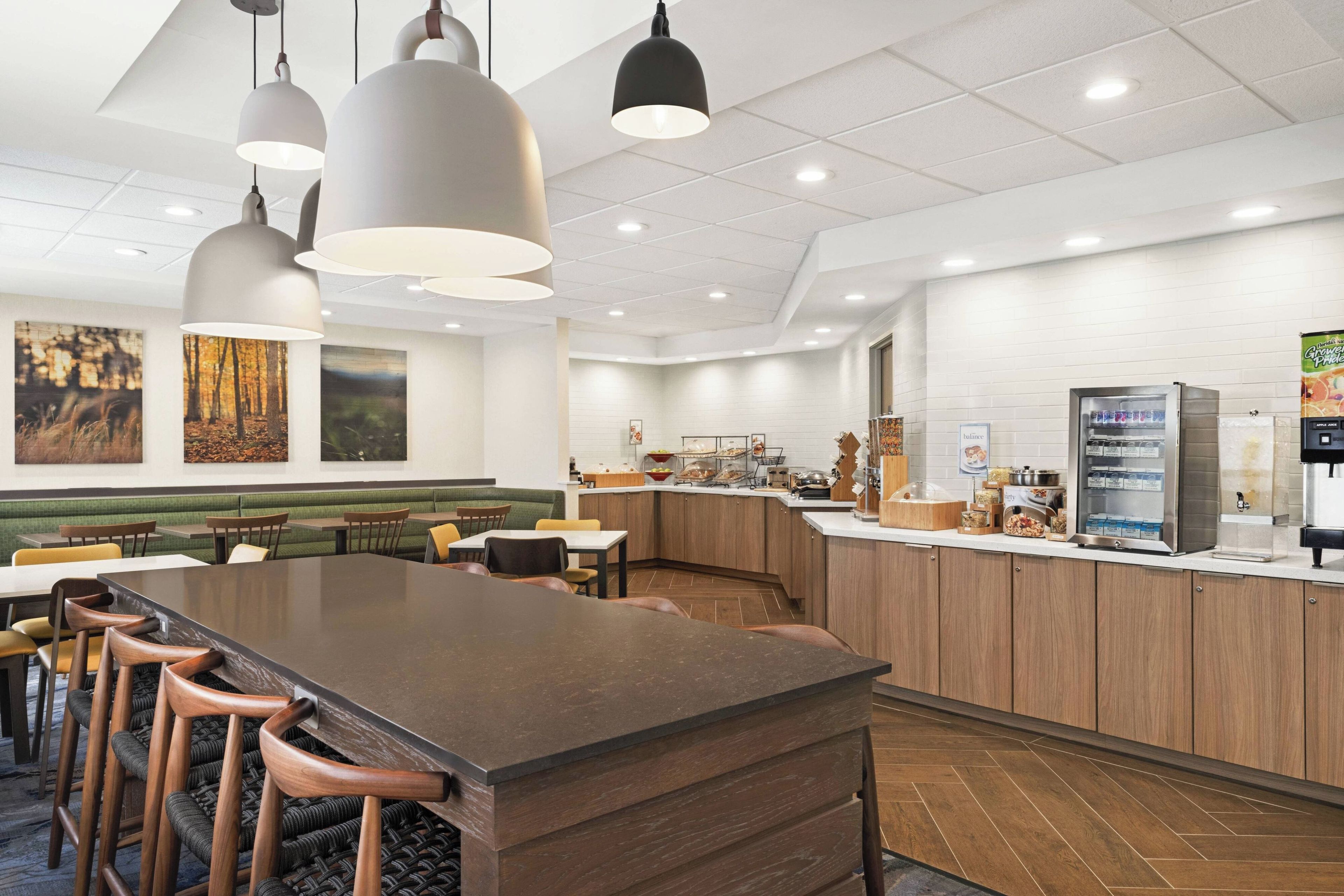 A modern restaurant with a central bar area, booths, and a counter with a coffee machine.