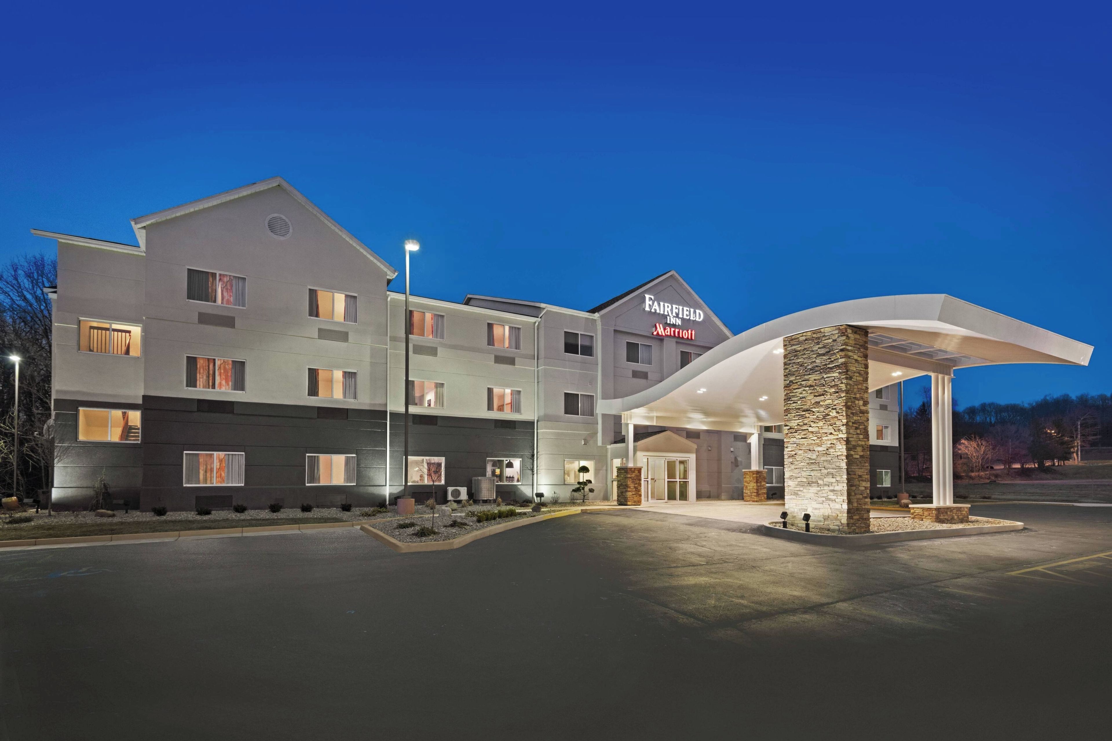 A Fairfield Inn & Suites by Marriott hotel with a modern design, featuring a spacious entrance and a well-lit facade.