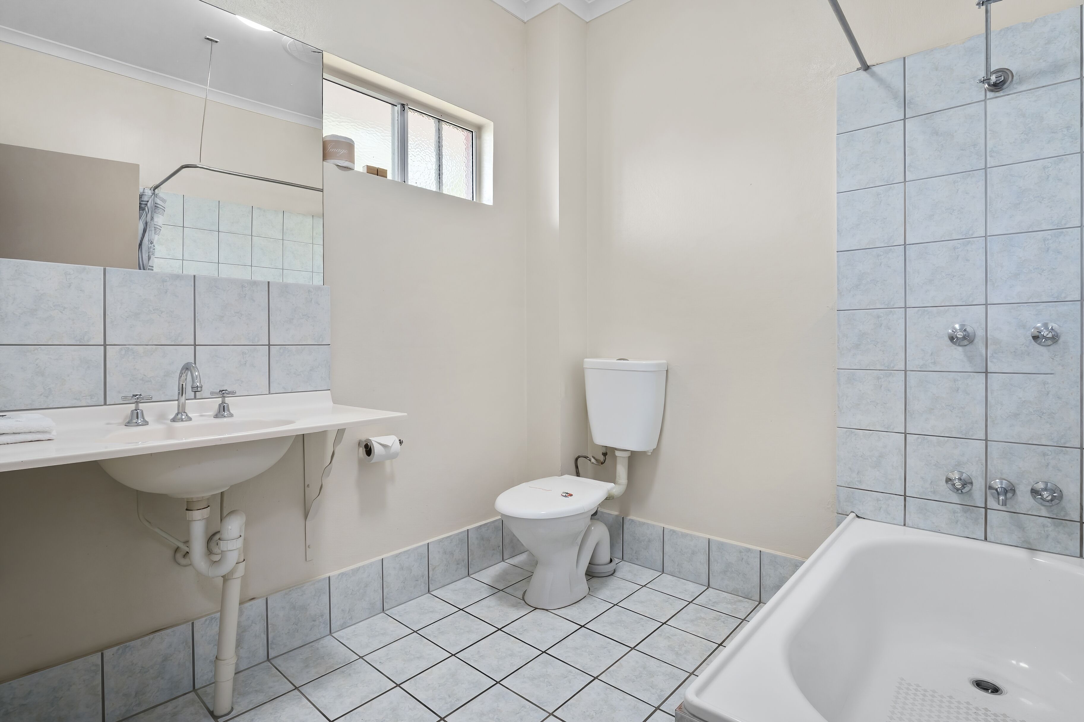 A bathroom with a white sink, toilet, and bathtub.