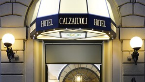 The entrance to Hotel Calzaiuli with a sign above the door and a lamp on either side. - FH55 Hotel Calzaiuoli (Florence)