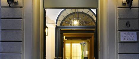La entrada al Hotel Calzaiuli, con un letrero sobre la puerta y una lámpara a cada lado.