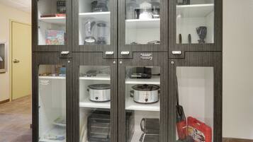 A kitchen cabinet with multiple compartments, including shelves for appliances and storage.