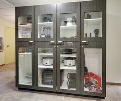 A kitchen cabinet with multiple compartments, including shelves for appliances and storage.