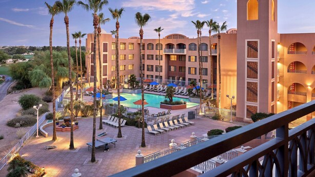 A hotel with a swimming pool surrounded by palm trees and lounge chairs. - Scottsdale Marriott at McDowell Mountains (Scottsdale)