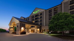 Un hotel Wyndham Garden de diseño moderno, con una entrada destacada, varios balcones y una fachada bien iluminada.