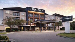 A Courtyard by Marriott hotel with a covered entrance, multiple balconies, and a landscaped entrance area. - Courtyard by Marriott Myrtle Beach Broadway (Myrtle Beach)
