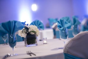 A table set with a vase of white flowers, a candle, and a fork. - Crowne Plaza Memphis Downtown by IHG (Memphis)
