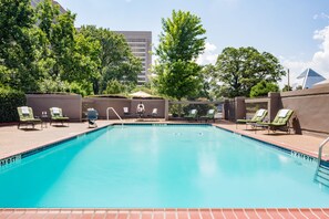 Una piscina al aire libre de temporada, sombrillas, tumbonas
