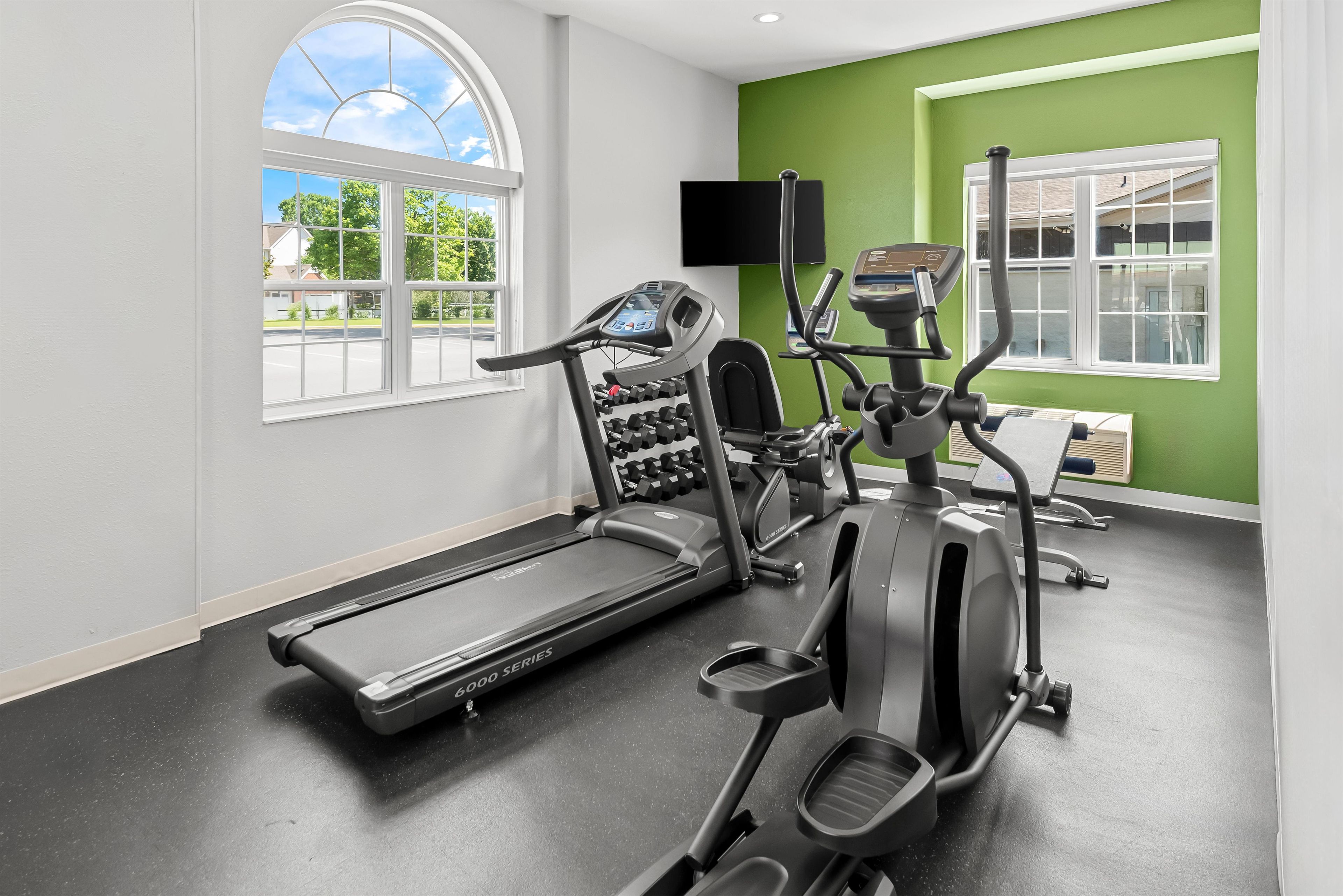 A gym with exercise equipment, a treadmill, and a stationary bike.