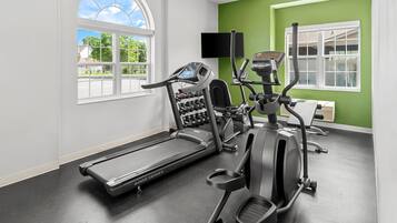 A gym with exercise equipment, a treadmill, and a stationary bike.