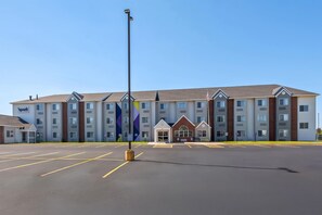 A multi-story hotel with a parking lot in front.