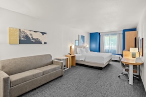 A hotel room with a bed, a sofa, a desk, and a chair. - Spark by Hilton Appleton (Appleton)