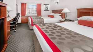A hotel room with two beds, a desk, a chair, and a window with curtains. - Ramada by Wyndham Frisco (Frisco)