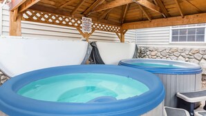 Two hot tubs with wooden benches under a wooden pergola. - Ramada by Wyndham Frisco (Frisco)