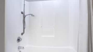 A white bathtub with a showerhead and faucet.
