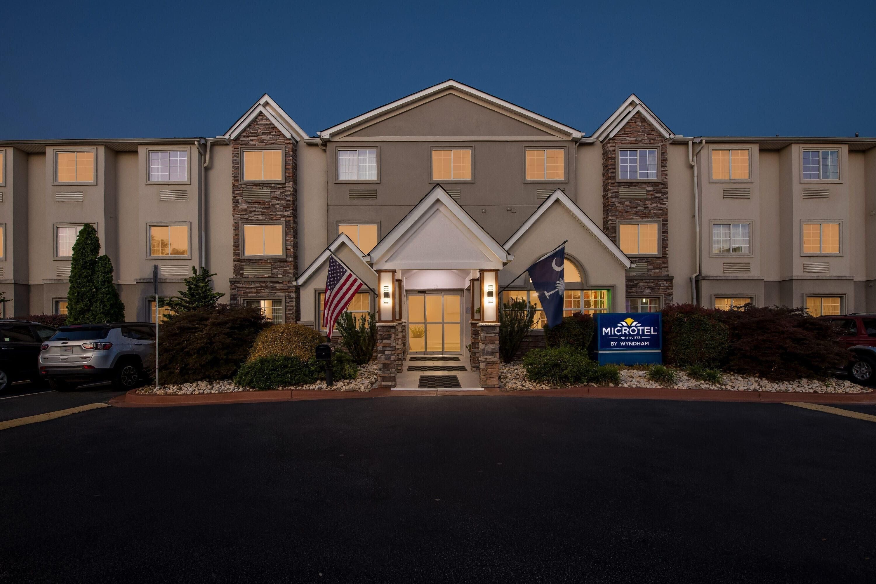 A hotel with a central entrance, multiple windows, and a flag.