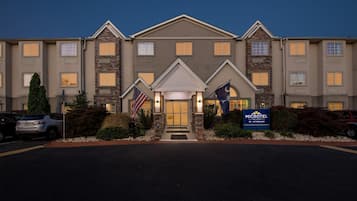 A hotel with a central entrance, multiple windows, and a flag.