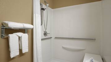 A shower area with a white showerhead, a handheld showerhead, and a glass-enclosed toilet.