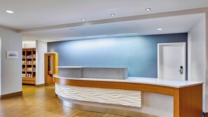 Una reception dal design moderno, con un bancone in legno e una parete blu sullo sfondo.