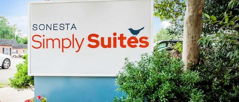 A sign for Sonesta Simply Suites with a bird logo.