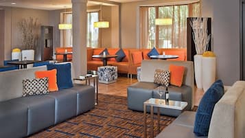 Relax in our stylish lobby, featuring a seating area with sofas and armchairs, a small table for refreshments, and large windows.