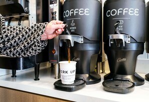 A coffee machine dispensing coffee into a cup labeled "BEER UP!". - Sonesta ES Suites Raleigh Cary (Cary)