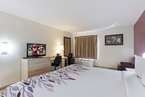 A hotel room with a bed, a desk with a computer, a television, a chair, and a window with curtains. - Red Roof Inn London I-75 (London)