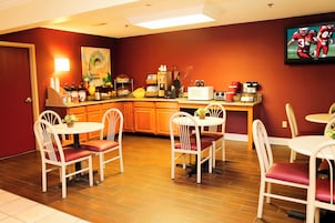 Cocina compacta con comedor, equipada con refrigerador, microondas y cafetera.