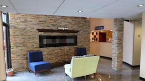 A lobby with stone walls, a reception desk, and seating areas.