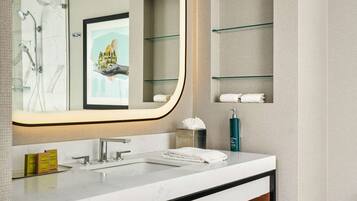 Une salle de bain moderne avec un grand miroir, un lavabo en marbre, un meuble-lavabo en bois et un porte-serviettes.
