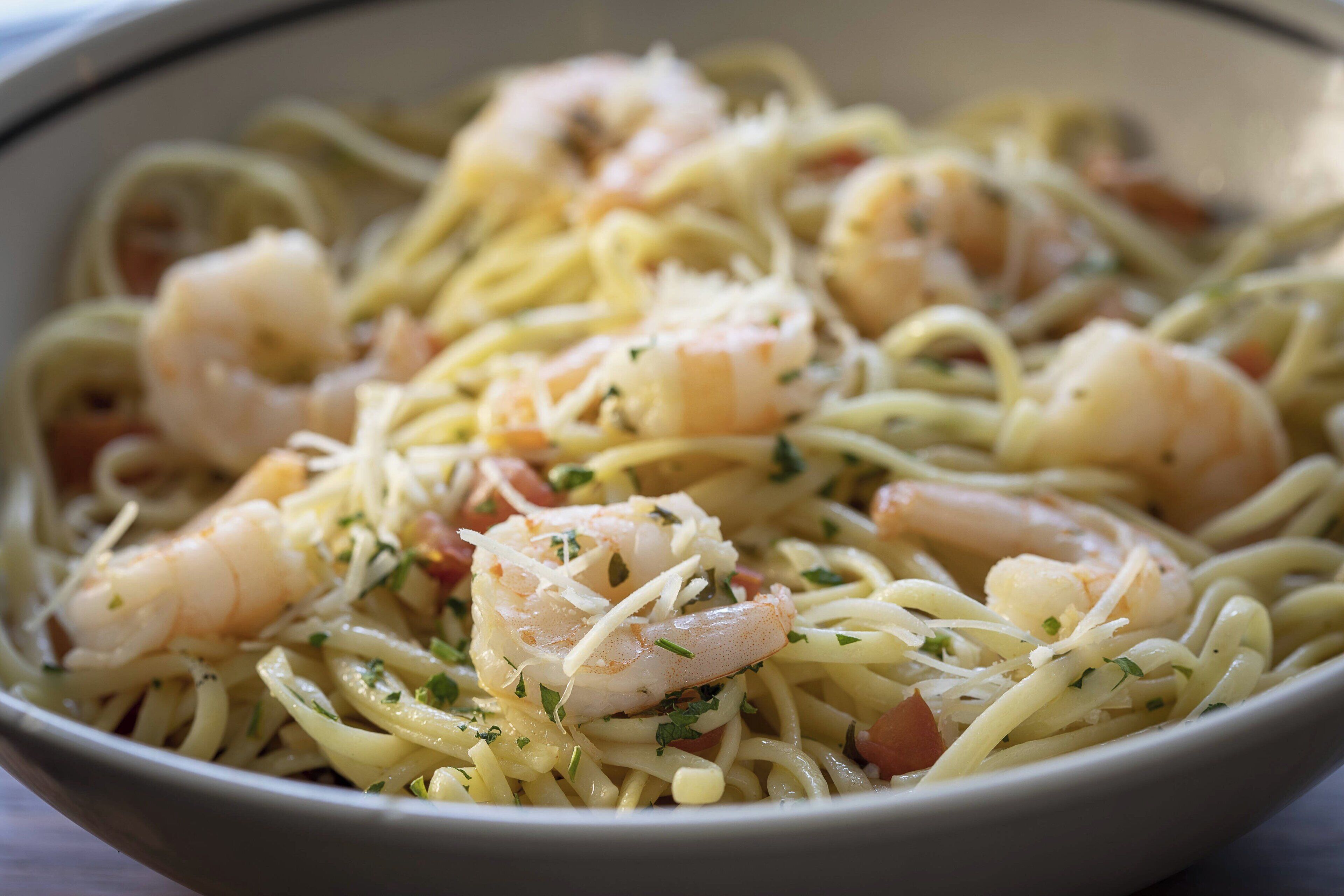 A bowl of pasta with shrimp and cheese.