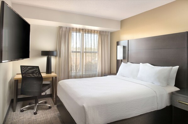 A hotel room with a bed, a desk, a chair, a TV, and a window with curtains. - Sonesta ES Suites Raleigh Durham Airport Morrisville (Morrisville)