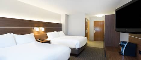 Habitación de hotel con dos camas, televisión y minibar.