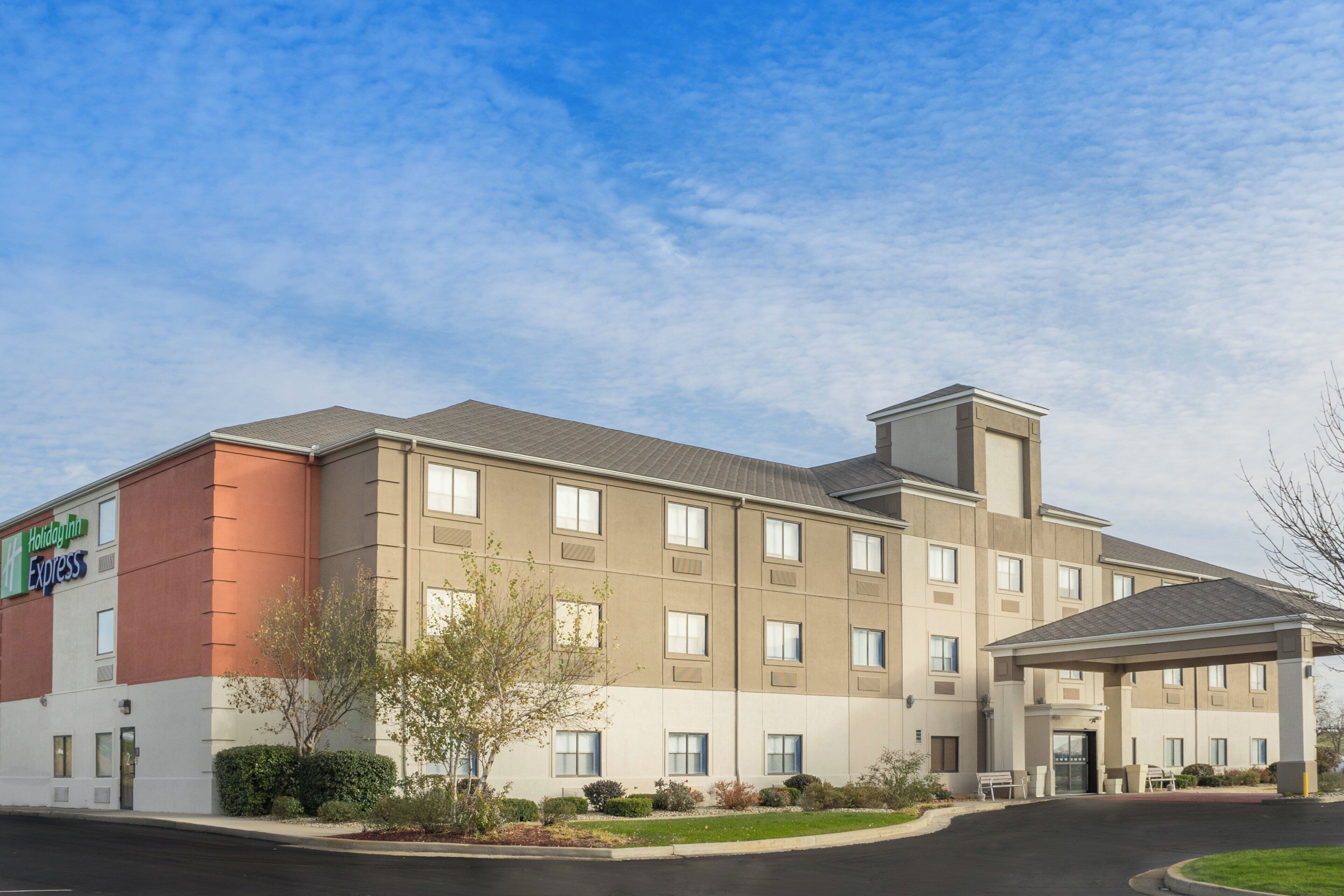 A Holiday Inn Express hotel with a modern design, featuring a flat roof, multiple windows, and a covered entrance.