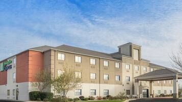A Holiday Inn Express hotel with a modern design, featuring a flat roof, multiple windows, and a covered entrance.