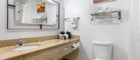 Ein Badezimmer mit Marmorwaschtisch, Spiegel, Toilette und Handtuchhalter.