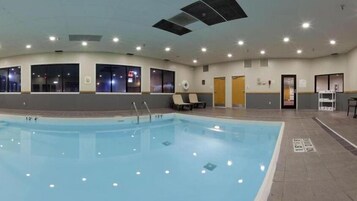 Una piscina interior con carriles delimitados, suelo de baldosas e iluminación empotrada en el techo.