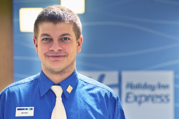 A man in a blue shirt with a name tag reading "MICHAEL" and a white tie. - Holiday Inn Express Hotel & Suites Colby by IHG (Colby)