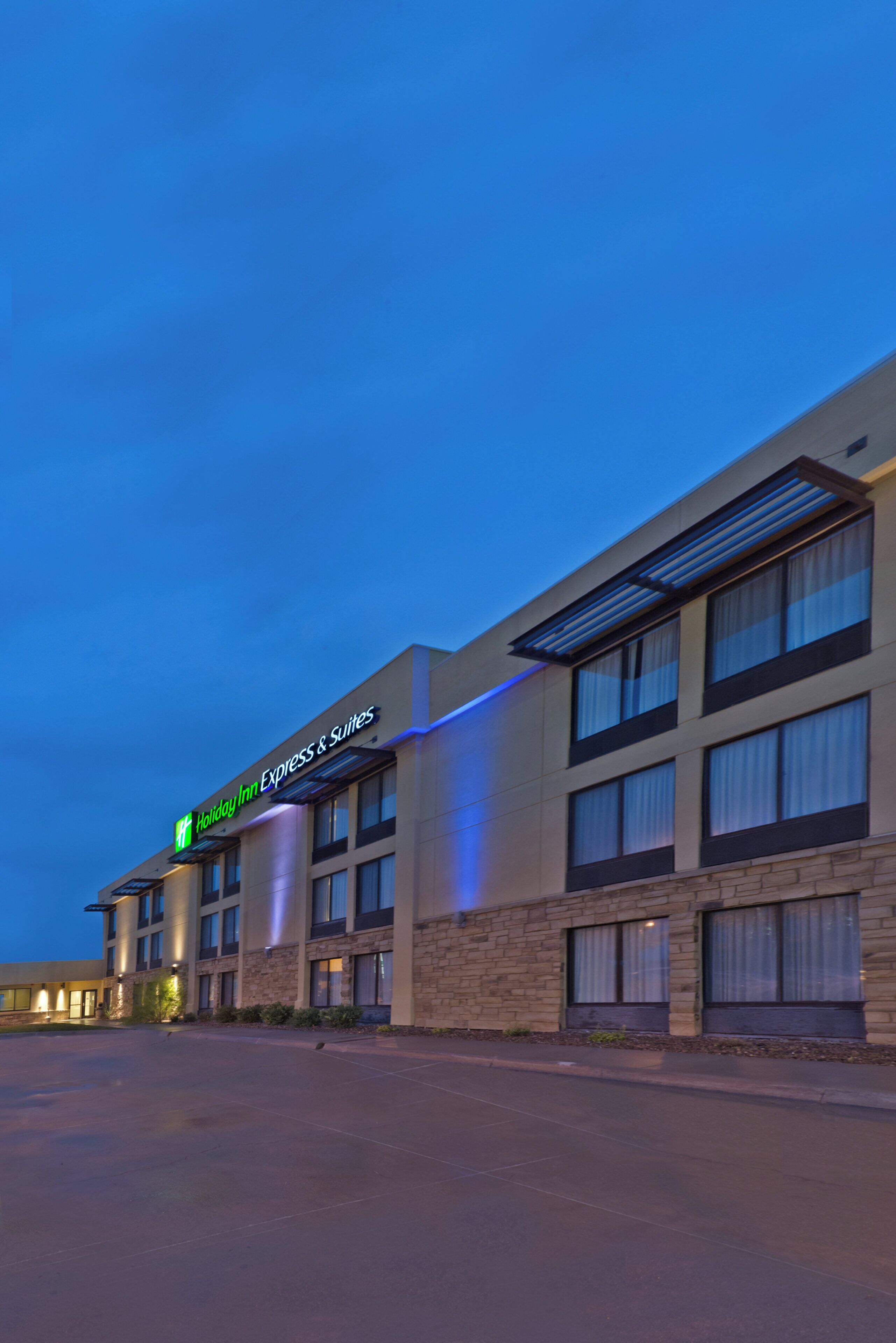 Un hotel Holiday Inn Express & Suites con un diseño arquitectónico moderno, con techo plano y amplias ventanas.
