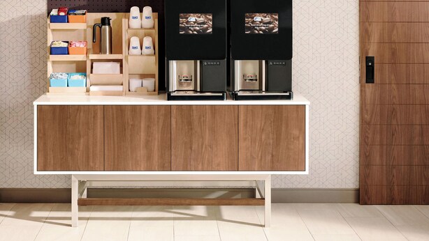 A modern kitchen with a wooden countertop, built-in coffee machines, and storage cabinets. - Holiday Inn Express & Suites Atlanta N-Perimeter Mall Area by IHG (Atlanta)