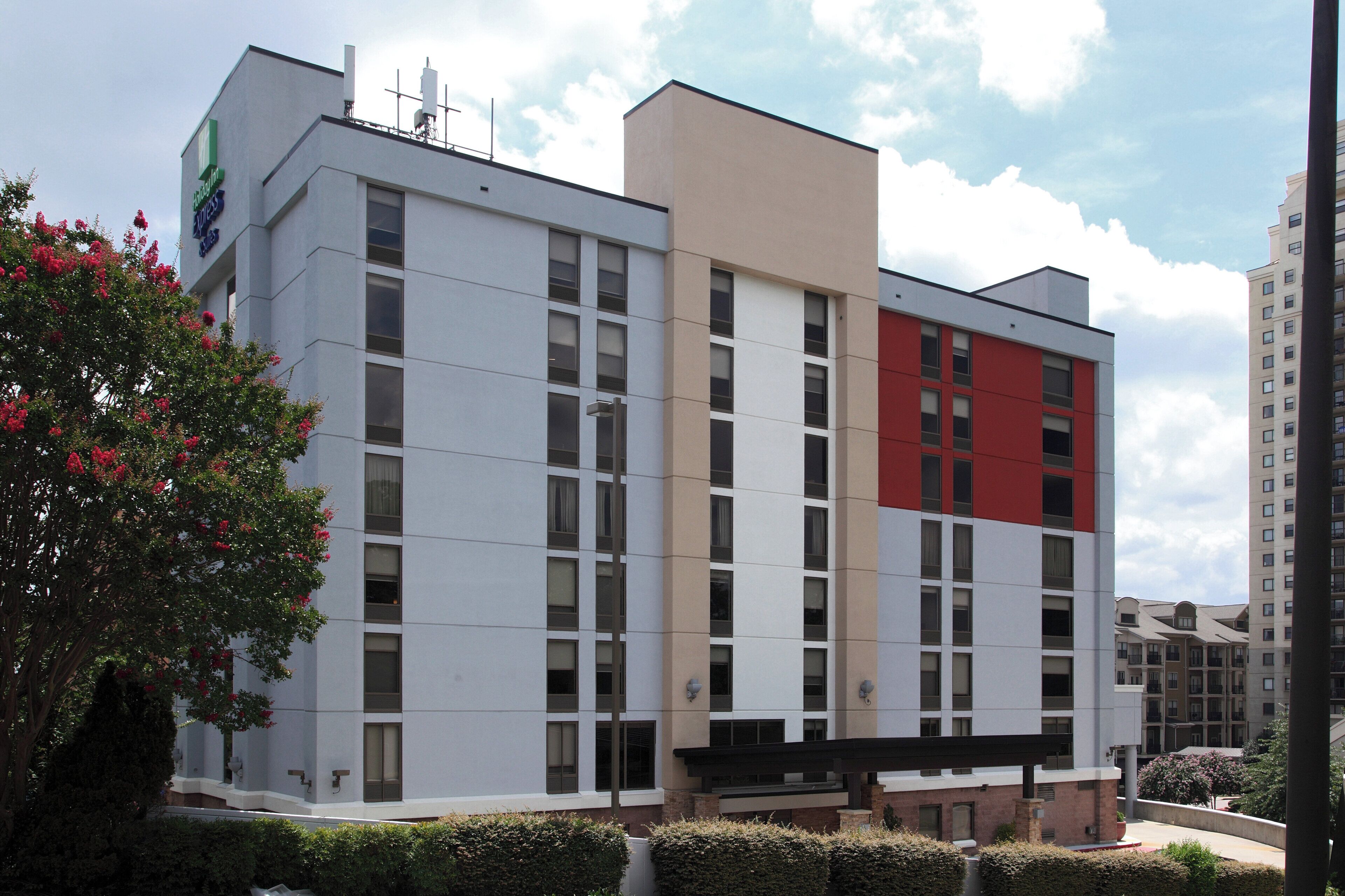 A multi-story building with a flat facade, large windows, and a section with a red accent.