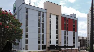 A multi-story building with a flat facade, large windows, and a section with a red accent.