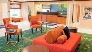 Een hotel lobby met een receptiebalie, een zithoek en een uitzicht op de receptie.