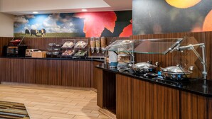 A buffet area with a wooden counter, food containers, and a mural of cows on a field. - Fairfield Inn and Suites by Marriott Denver Aurora/ Medical Center (Aurora)