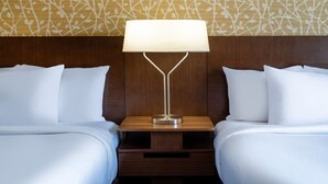 A hotel room with two beds, a nightstand with a lamp, and a patterned wall. - Fairfield Inn and Suites by Marriott Denver Aurora/ Medical Center (Aurora)