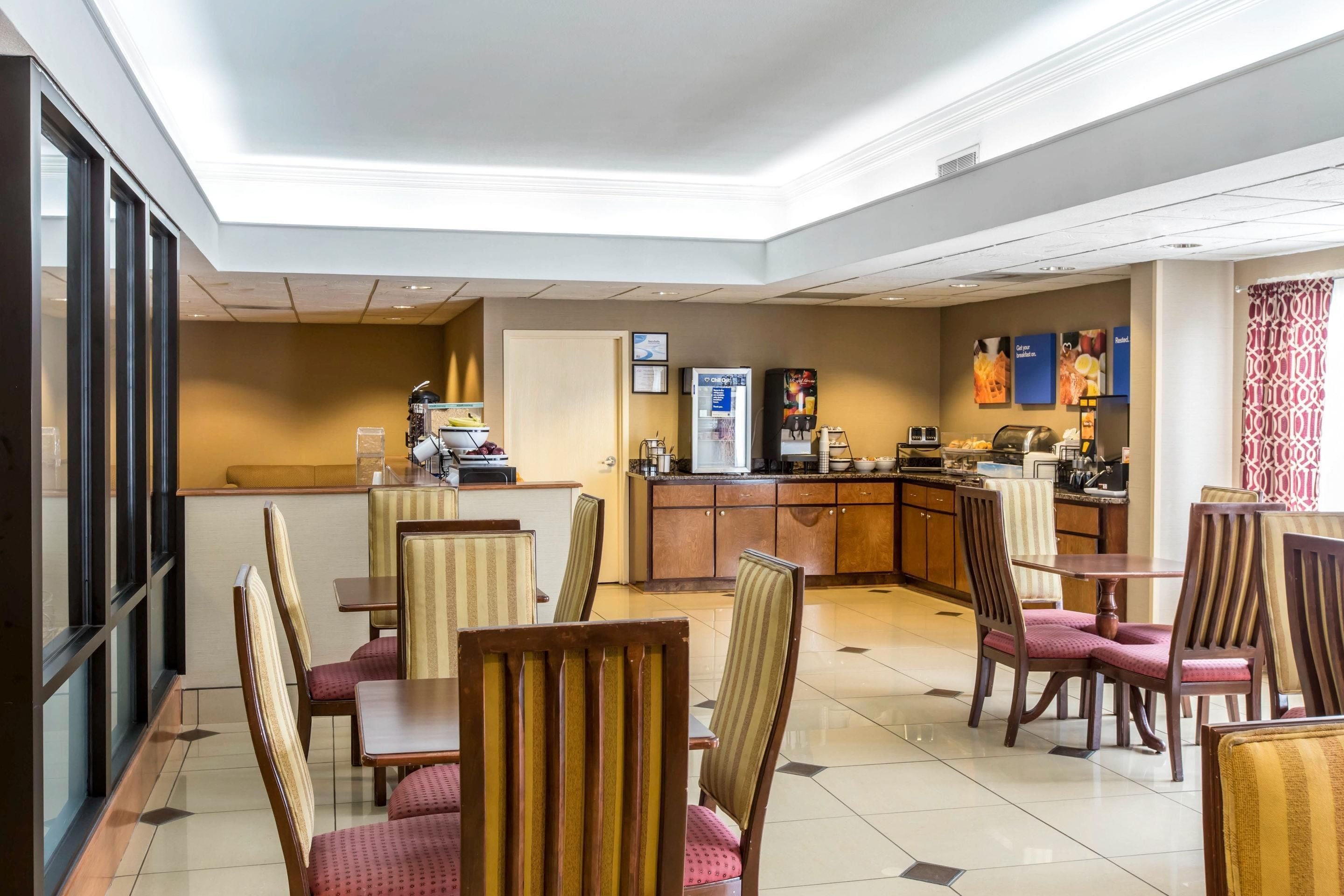 Un hall d’hôtel comprenant un espace repas, un comptoir d’accueil et une cuisine.